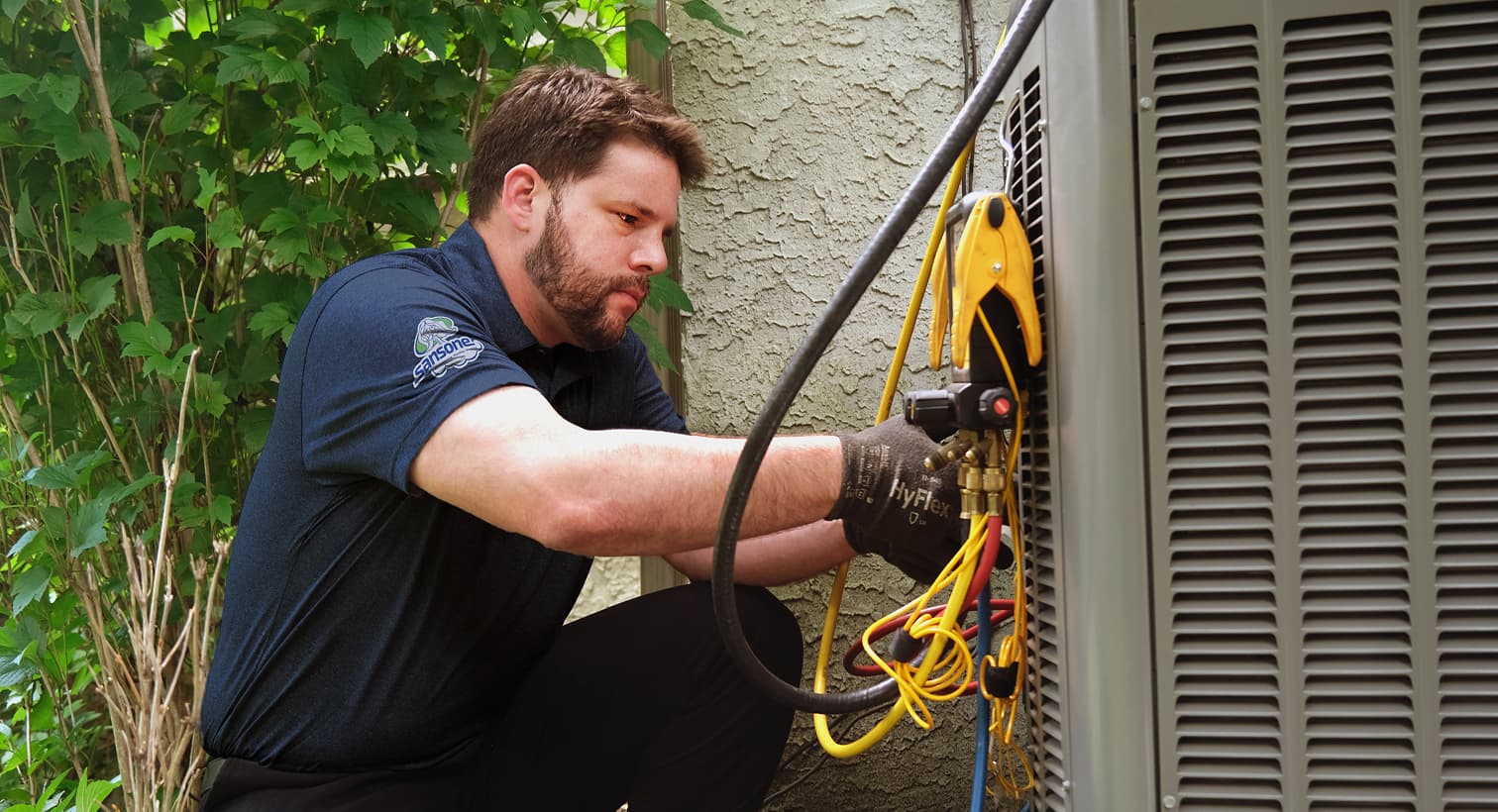 A professional Sansone HVAC technician inspecting an outdoor central air conditioning unit to provide residential AC repair and diagnostic services.