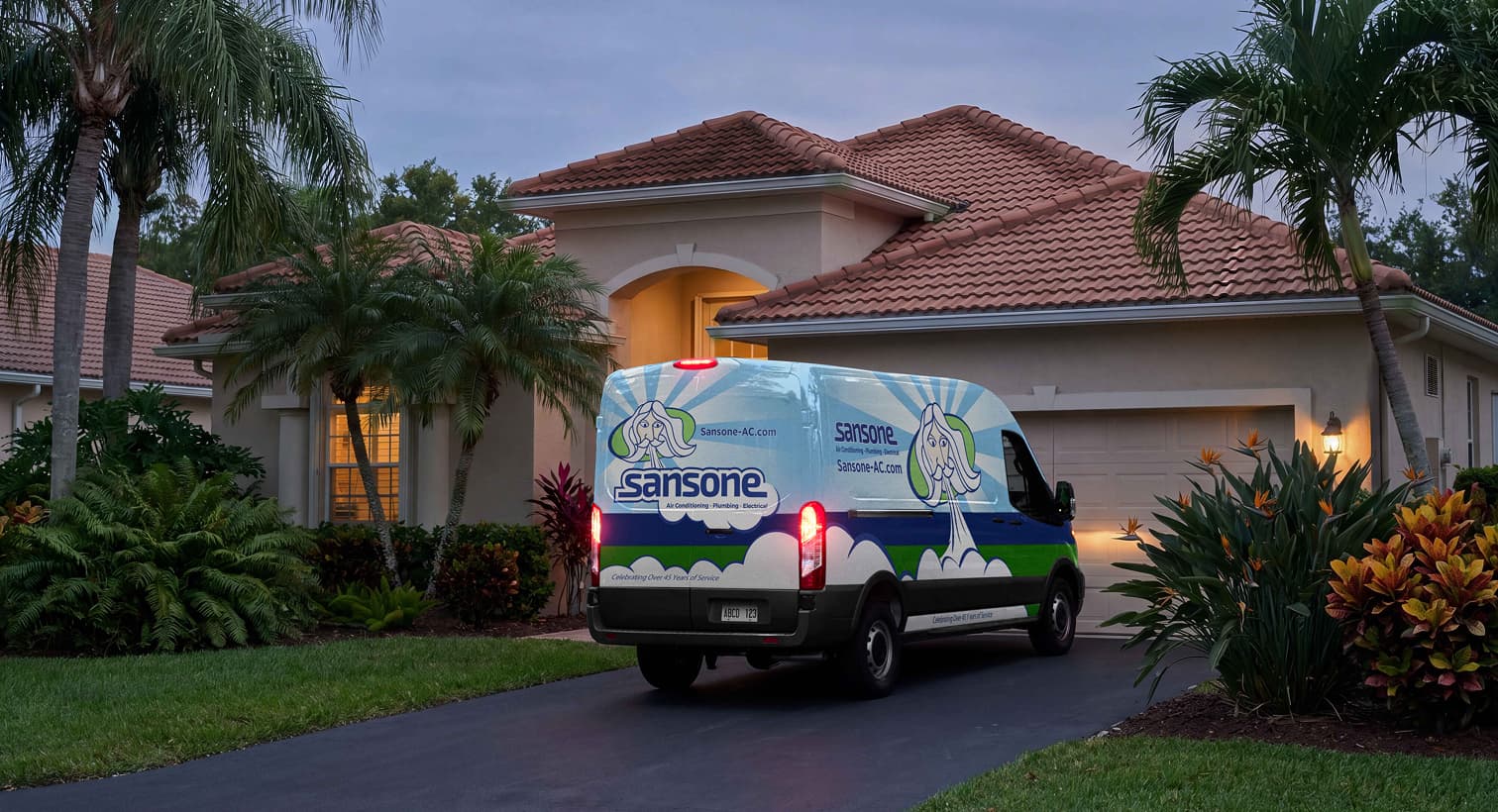 A Sansone service van parked in a residential driveway at night, arriving to provide 24/7 emergency plumbing services.
