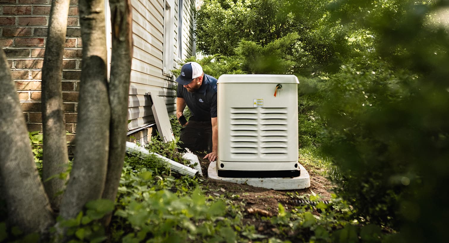 A professional Sansone technician inspects a large, beige whole-home standby generator installed on a concrete pad outside a residential house.